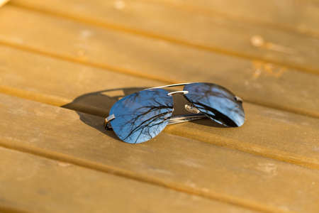 Aviator sunglasses model with big silver lenses shoot outside in a sunny day closeup . Selective...