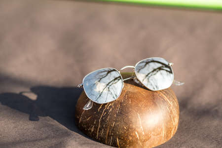 Classic sunglasses model with silver round golden lenses shoot outside in a summer day closeup . Selective focusの写真素材