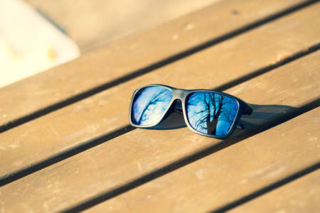 Classic Sunglasses model with blue lenses shoot outside in a summer day. Selective focusの写真素材