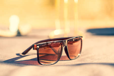 Classic Sunglasses design for men and ladies with brown lenses and brown frame shoot outside in a summer day closeup. Selective focusの写真素材