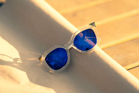 Futuristic Sunglasses special model with blue lenses reflecting the sun in a summer day shoot outdoors closeup . Selective focusの写真素材