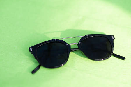 Black sunglasses classic design with black lenses and black frame shoot in a sunny day of summer closeup. Selective Focusの写真素材
