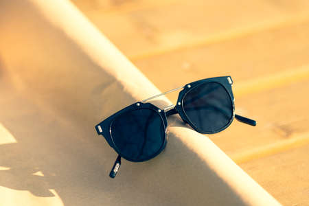 Black sunglasses classic design with black lenses and black frame shoot in a sunny day of summer...