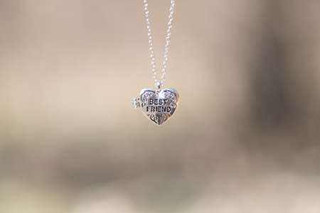 Pendant Best Friend heart necklace shoot outside in a summer day closeup. Selective Focusの写真素材