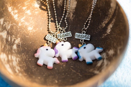 Pendant set of best friends forever three unicorns necklace shoot outside in a summer day closeup. Selective Focusの写真素材