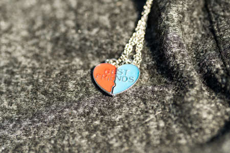 Pendant set of best friends two colors heart necklace shoot outside in a summer day closeup. Selective Focusの写真素材