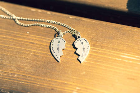 Pendant Best friends heart two parts necklace shoot outside in a summer day closeup. Selective Focusの写真素材