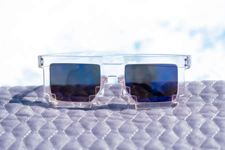 Blue lenses pixel sunglasses model shoot in a summer day closeup. Selective focus