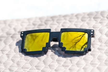 Golden lenses pixel 8bit sunglasses design shoot in a summer day closeup.Thug life model. Selective focusの写真素材