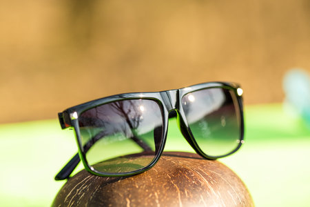 Classic Sunglasses design for men and ladies with black lenses and black frame shoot outside in a summer day closeup. Selective focusの写真素材