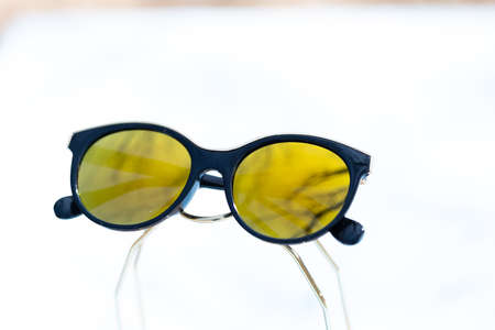 Fashion cat eye sunglasses for ladies with big round yellow lenses and black frame shoot outside in a sunny day closeup. Selective focusの写真素材