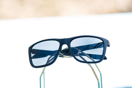 Classic Sunglasses design with black lenses and black frame shoot outside in a sunny day. Selective focusの写真素材