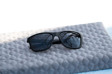 Classic Sunglasses design with black lenses and black frame shoot outside in a sunny day. Selective focusの写真素材