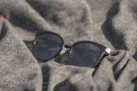 Classic sunglasses model for ladies with black round lenses shoot outside in a sunny day closeup ....
