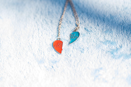 Pendant set of best friends two colors heart necklace shoot outside in a summer day closeup. Selective Focusの写真素材