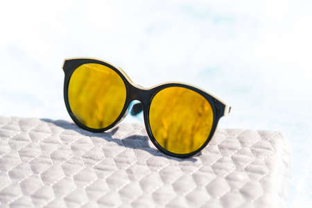Fashion cat eye sunglasses for ladies with big round yellow lenses and black frame shoot outside in a sunny day closeup. Selective focusの写真素材