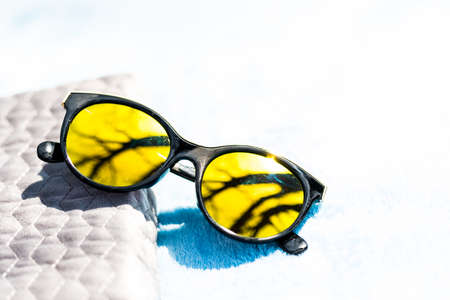 Fashion cat eye sunglasses for ladies with big round yellow lenses and black frame shoot outside in a sunny day closeup. Selective focusの写真素材