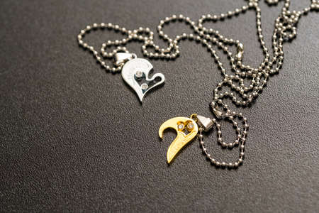 Couple set pendant necklace half of heart gold and sliver color shoot closeup. Selective focusの写真素材