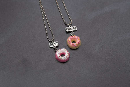Pendant set of best friends two donuts necklace closeup. Selective Focus