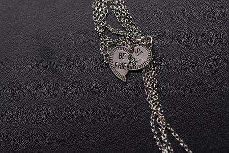 Pendant of best friends heart in two parts necklace closeup. Selective Focusの写真素材