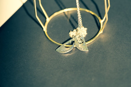 Couple set pendant necklace two half of a heart shoot outdoors in a sunny day closeup. Selective focusの写真素材