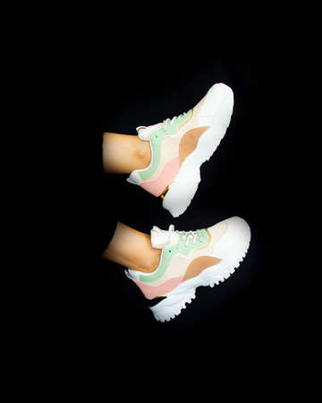 Product photography: colorful women's sneakers on black background.