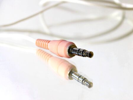 Computer's pink connection cable on reflective surfaceの写真素材