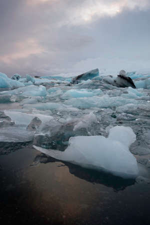Glacial ice blocks in calm water in Jokulsarlon lake, Icelandの写真素材