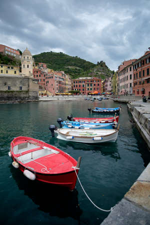 Dramatic cloudy sky over Vernazza harbor, with some boats in the foreground. Cinque Terre, Italy.のeditorial素材