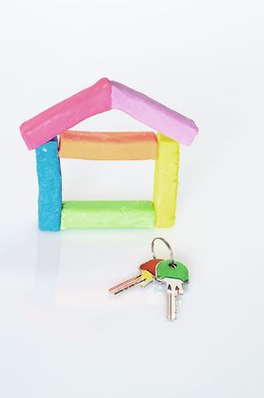 house composed of colored clay on a white background with two keys of different colorsの写真素材
