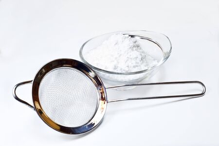 colander and Powdered sugar on white backgroundの写真素材