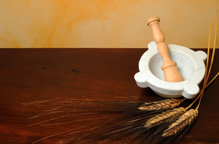 Flour, wheat ears and mortar on wood tableの写真素材