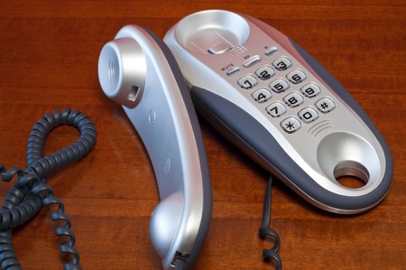 Telephone metallic gray on a dark wooden tableの写真素材