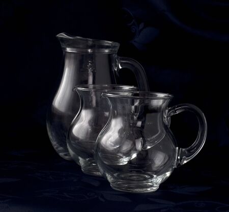 Pitchers three glass diverese capacity on a dark backgroundの写真素材