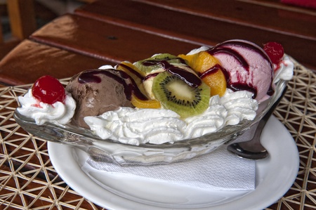 a portion of a banana split with fresh fruit toppingsの写真素材