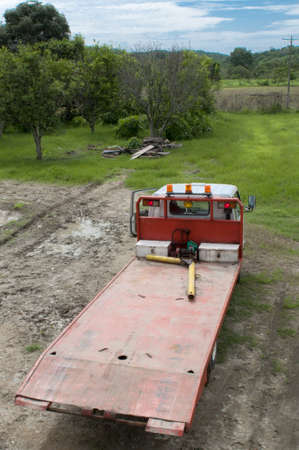 one red tow-truck waiting in a field