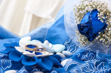 a  blue roses and wedding rings on white backgroundの写真素材