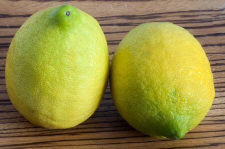 organic lemons on a wooden cutting boardの写真素材