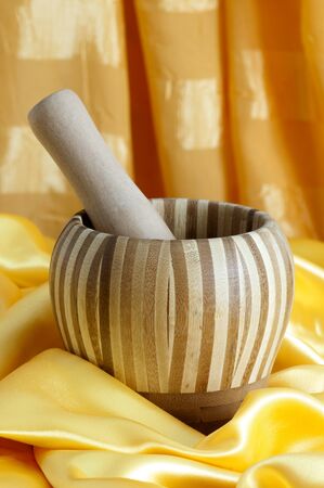 a bamboo mortar over a yellow fabricの写真素材