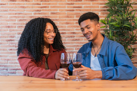 Joyful Couple Celebrating Their Love While Toasting With Elegant Glasses Of Red Wine In A Cozy Setting Filled With Laughter And Happiness, Creating Memorable Moments Togetherの写真素材