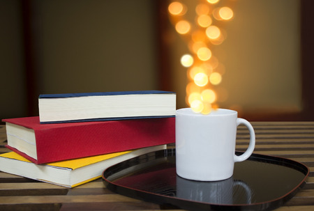 Coffee and books with lights bokeh の写真素材