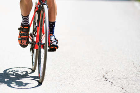 Close-up of the foot of a young man cycling on the road. sport conceptの写真素材