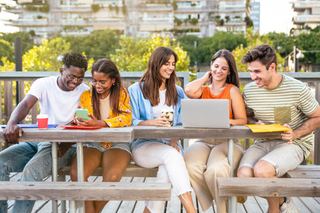 Cheerful group of university students studying for exam in the campus - Multicultural group of friends working together outdoors.の写真素材
