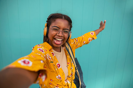 cheerful young girl taking selfie self portrait photo on smartphone - female showing positive face emotionの写真素材