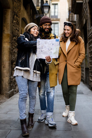 Three multiracial tourists friends looking map on city street outdoors - Fun, friends, travel and tourism conceptの写真素材