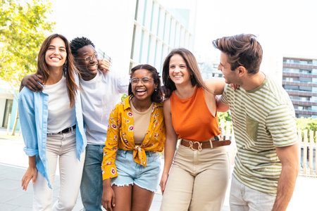 Group of smiling multiracial friends having fun outdoors - Cheerful young people laughing together at city - Friendship concept.の写真素材