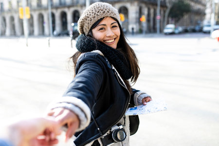 Cheerful young woman holding hands with crop manの写真素材