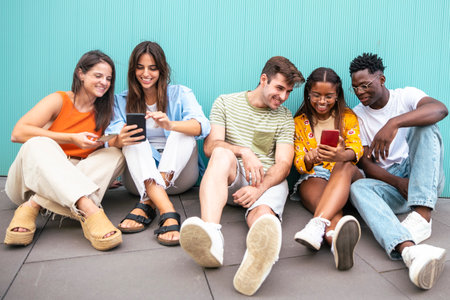 five happy young friends looking mobile phone and smiling with the content - happy teenagers with a smartphone - Lifestyle conceptの写真素材