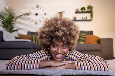 Happy young beautiful woman relaxing at home looking at camera. portrait of smiling female lying on the floor. Lifestyle conceptの写真素材