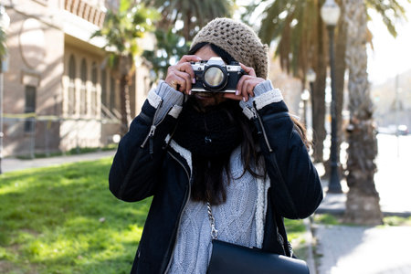 smiling woman traveler holding a camera at the city in holidays - relaxation, tourism conceptの写真素材